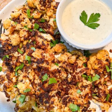 Skillet Buffalo Cauliflower on dinner plate with dip