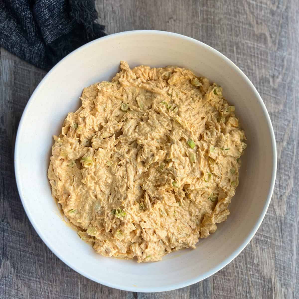 The base of the buffalo chicken dip is all mixed together before it gets transferred from the mixing bowl into a baking dish.