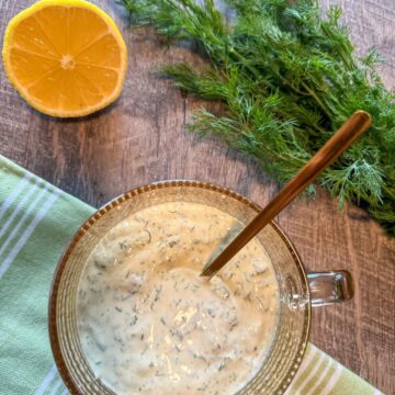 Creamy Dill Dressing in glass cup with gold spoon